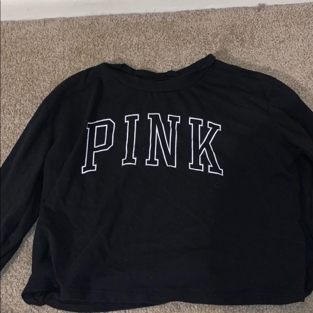 A black long sleeve shirt , printed pink across